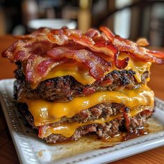 a cheeseburger with bacon is stacked on a plate