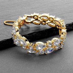 Bold Gold CZ Wedding Bracelet Made with glistening 3A quality teardrop and round cubic zirconia crystals, this beautiful 14K gold plated wedding bracelet will add a glamorous touch to any wedding or formal affair. At 6 1/2" long, its petite size is perfect for the bride or her bridesmaids with smaller wrists. Size: 6 1/2" long. Style: 4128B-G. Color: Gold. Need several bracelets for your wedding party? You can buy in bulk and save! Please allow 1 week for delivery. Shipping Policy . Return Polic Gold Wedding Bracelet, Crystal Wedding Bracelet, Silver Wedding Bracelet, Gold Bracelet Wedding, Silver Bridal Jewellery, Long Statement Earrings, Bridal Earrings Chandelier, Bridal Accessory, Bracelet Tennis