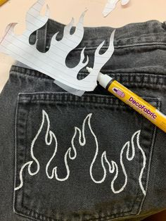 a pair of jeans that have been cut out to look like flames with a marker