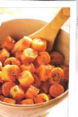 a wooden spoon in a bowl filled with carrots