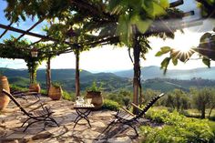 the sun shines brightly on an outdoor patio with chairs and table set up for two