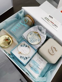 an open box containing jewelry and other items on a table with the word happy written in it