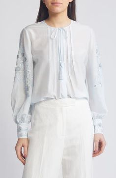 Swirling embroidery and sparkling sequins adorn the sleeves of this blousy silk-enriched top designed with a tassel-tie neck. 27" length Ties at neck Long sleeves 70% cotton, 30% silk Dry clean Imported Elegant Tops With Embroidered Cuffs, Elegant Fitted Tops With Embroidered Cuffs, Elegant Tops With Intricate Embroidery For Spring, Festive Long Sleeve Blouse With Embroidered Cuffs, Silk Long Sleeve Tops With Floral Embroidery, Spring Embellished Silk Tops, Silk Tops With Floral Embroidery And Long Sleeves, Festive Long Sleeve Tops With Embroidered Sleeves, Silk Blouse With Embroidered Long Sleeves