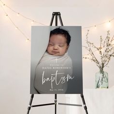 an easel with a baby's photo on it and lights in the background