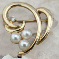 This is the perfect option for those who like cool, unique jewelry, and luxury. This brooch is well made, cute and/or elegant in design, and very desirable. The brooch is decorated with 3 pearls and a diamond. It has the shape of a heart. The clasp is in very good working condition. ♥ Age/Era: Circa before the 2002s. ♥ There is a hallmark. 14K. ♥ The brooch is about 1'' by 1''. ♥ The weight is about 4.3 gr. Everyone interested in the jewelry should remember that he or she must like their jewelry Elegant Heart-shaped Wedding Brooch, Elegant Brooch For Valentine's Day, Elegant 14k Yellow Gold Brooches, Elegant 14k Yellow Gold Brooch, Elegant Valentine's Day Brooch Jewelry, Elegant Valentine's Day Brooch, Elegant Heart Shaped Brooch Jewelry, Yellow Gold Fine Jewelry Brooches For Anniversary, Fine Jewelry Yellow Gold Anniversary Brooches