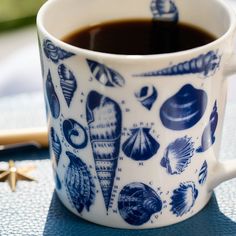 a blue and white coffee cup sitting on top of a table