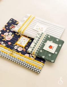 several different types of quilts are laying on the table together, including one with an apple