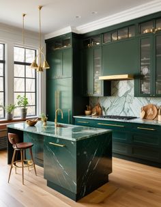 a kitchen with green cabinetry and marble counter tops, along with wooden flooring