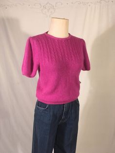 "vintage 1980s pullover sweater Gloria Vanderbilt Knitwear 55% silk, 33% nylon, 10% angora rabbit hair, 2% lambswool made in Hong Kong raspberry purple short puff sleeve cable knit pattern down front never worn w/tags good vintage condition, light age wear labeled size M, see below measures, lying flat, shouler-13 1/2\" chest-16\" sleeve-9\" length-21\"" Vintage Short Sleeve Winter Tops, Winter Cable Knit Short Sleeve Sweater, Pink Short Sleeve Sweater For Winter, Fitted Cable Knit Short Sleeve Tops, Retro Fitted Textured Knit Tops, Fitted Textured Knit Short Sleeve Sweater, Fitted Short Sleeve Cable Knit Tops, Vintage Knit Sweater With Short Sleeves, Fitted Vintage Short Sleeve Sweater