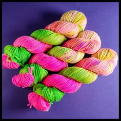 several skeins of colorful yarn on a purple background