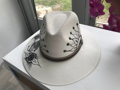 Hand Painted Fedora Hats, Artisan Hat For Spring Vacation, Artisan Spring Vacation Hat, Handmade Toquilla Straw Panama Hat For Spring, Spring Handmade Panama Hat In Toquilla Straw, White Hand Painted Flat Brim Hat, Handmade Toquilla Straw Fedora For Spring, Artistic White Hat With Short Brim, White Artistic Short Brim Hat