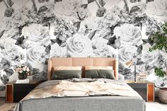 a large bed sitting in front of a wall with flowers painted on it's side