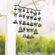 a metal bell with bells hanging from it's side and butterflies on the front