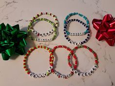 four personalized bracelets with bows and ribbons on a table next to a bow