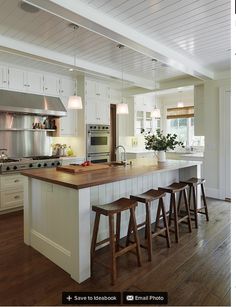 a kitchen island with stools in front of it and an open floor plan on the wall