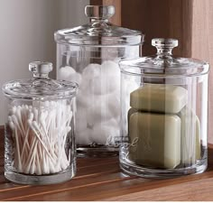 three glass containers with candles and marshmallows in them