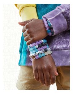 two people wearing bracelets with beads on their wrists and one holding the other's hand