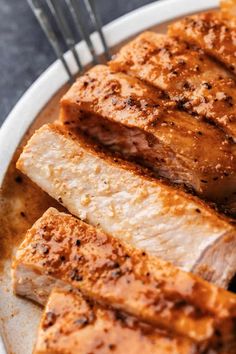 grilled meat on a plate with fork and knife