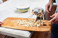 a person cutting up some food on top of a wooden board