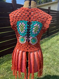 Experience the charm of bygone eras with our stunning crochet vintage inspired orange butterfly vest. This handmade vest brings together a rust style orange with a beautiful array of colors, meticulously crocheted into a captivating butterfly design that adds a whimsical touch to any wardrobe. Crafted with love and care, this vest is unique, ensuring that you wear a piece of art that stands out in any setting, be it a casual day out or a lively festival. Made from scrap acrylic yarns, this vintage inspired vest promises not only style but also comfort and durability. The vest is designed to fit various body types with ease, thanks to its flexible and breathable material. Measuring at a versatile size, it suits a range of bust and waist sizes, making it a perfect layering piece over dresses Handmade Bohemian Vest For Spring, Handmade Sleeveless Vest For Festivals, Red Vest For Fall Festival, Red Bohemian Vest For Summer, Handmade Bohemian Vest For Festival, Bohemian Brown Vest For Festival, Vintage Fitted Crochet Top For Festival, Summer Bohemian Red Vest, Bohemian Brown Crochet Top For Festival