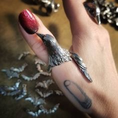 "Handcrafted lead-free pewter adjustable bird wrap ring. This ring is very adjustable but it's best if we set it close to your size. Also, the tail feathers will be slightly trimmed for sizes 8 & below. The pics with the black onyx eyes are an example of the trimmed. 2\" long or less depending on ring size Bird body ¾\" wide All pieces are made-to-order despite the \"in stock\" number in the listing. Time frame varies from piece to piece so please message us if you need something by a certai Adjustable Silver Jewelry With Bird Design, Hoarding Board, Crow Ring, Raven Ring, Onyx Eyes, Bird Clothing, Bird Ring, Bird Rings, Nail Ring