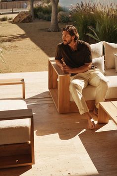 a man sitting on top of a wooden bench