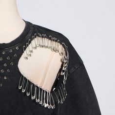 a woman's black top with silver spikes on it