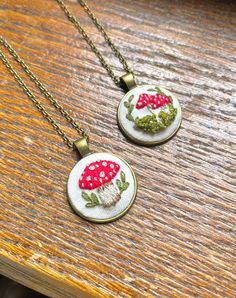 These beautiful hand embroidered wild mushroom necklaces make the perfect gift for a loved one or for mushroom lovers! All hand embroidered and set on a bronze gold pendant with chain. Please select which style you would like by choosing the above option. Only one style of each is available. When they're gone they're gone! For more information please send a direct message x Mushroom Necklaces, Aesthetic Embroidery, Hand Embroidered Pendant, Hand Embroidered Necklace, Hand Embroidered Jewelry, Embroidered Pendant, Mushroom Necklace, Wild Mushroom, Embroidered Necklace