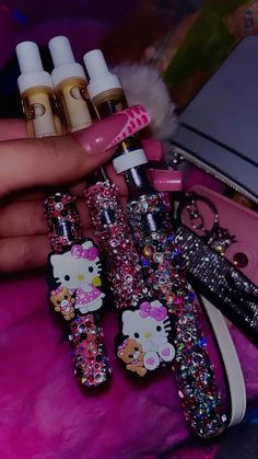 the hello kitty nail polish is next to some glittery brushes and other items on a pink surface