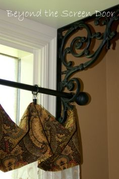 the curtain is hanging on the window sill in front of the window with an iron rod