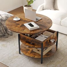 a living room with a couch, coffee table and laptop on top of the table