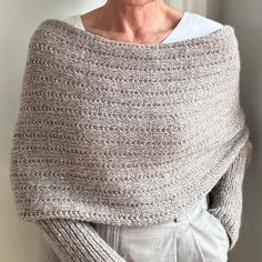 an older woman wearing a gray knitted shawl