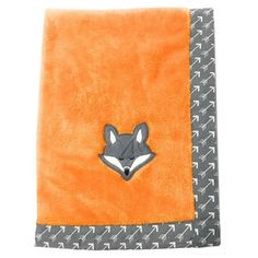 an orange and grey blanket with a fox patch on the front, sitting in front of a white background