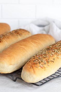 three loaves of bread sitting on top of a cooling rack next to each other