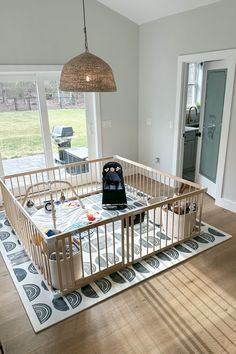 a baby crib in the middle of a living room with an open floor plan