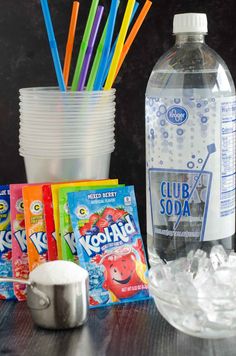 there are many drinks and snacks on the table with ice cubes next to it