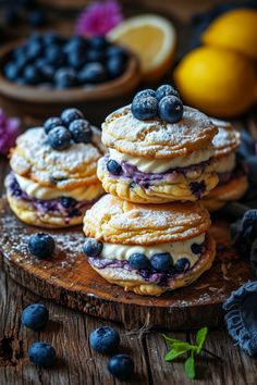 blueberry and lemon shortcakes on a wooden board with fresh fruit in the background