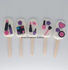 four pops decorated with makeup and nail polish