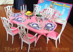 a pink table set with white chairs, plates and silverware on it in front of a barbie poster