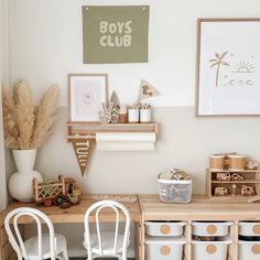 two white chairs sitting in front of a wooden desk with baskets on top of it