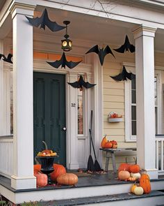 a porch decorated for halloween with bats and pumpkins