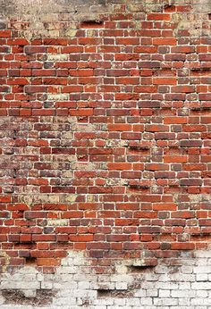 an old red brick wall with peeling paint