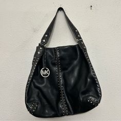 Size: One Size Condition: Excellent, Gently Used Color: Black, Silver Features: Studded All Over, Thick Leather Strap, **Flaw: Very Minor Staining On Interior Lining**, Heavy Quality Material **16” Width X 14” Height (Excluding Strap)** Leather Shoulder Bag With Silver-tone Hardware For Errands, Michael Kors Leather Shoulder Bag With Palladium Hardware, Silver Leather Shoulder Bag With Branded Hardware, Michael Kors Leather Bags With Silver-tone Hardware, Luxury Leather Bag With Silver Accents, Michael Kors Designer Shoulder Bag With Silver-tone Hardware, Designer Michael Kors Shoulder Bag With Silver-tone Hardware, Leather Evening Bags With Silver Accents, Evening Leather Shoulder Bag With Silver Accents