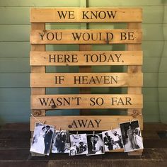 a wooden pallet with pictures hanging from it and some words written on the pallets