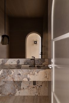 a bathroom with marble counter tops and an arched doorway leading to another room that has a mirror on the wall