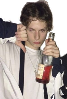 a young man holding a bottle of liquor in his right hand and looking at the camera