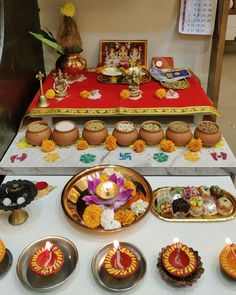 there are many bowls and plates on the table with candles in them, along with other decorative items