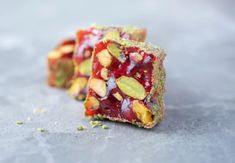 two pieces of food that are sitting on a counter top, one is filled with jelly and the other has almonds