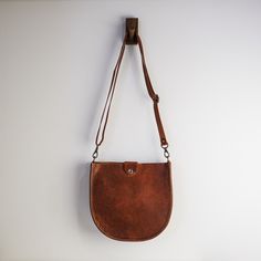 "With a classic saddle bag shape and convenient, magnetic snap closure, this is your new go-to bag. Easily fit everyday items including wallets, keys, phone, and more. We hand-cut buttery soft yet durable 5 oz Horween leather and stitch it with heavyweight nylon thread. The crossbody straps are available in multiple color options and are fitted with solid brass hardware. * Approximately 10\" x 10\" x 2\" * Crossbody strap drop adjusts from 16\" - 28\" * Magnetic snap closure * Unlined interior" Handmade Leather Bag Woman, Saddle Crossbody Bag, Crossbody Saddle Bag, Horween Leather, Leather Saddle Bags, How To Make Handbags, Saddle Bag, Small Crossbody Bag, Small Crossbody