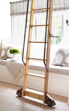 a ladder leaning up against a window in a room with white walls and windowsills